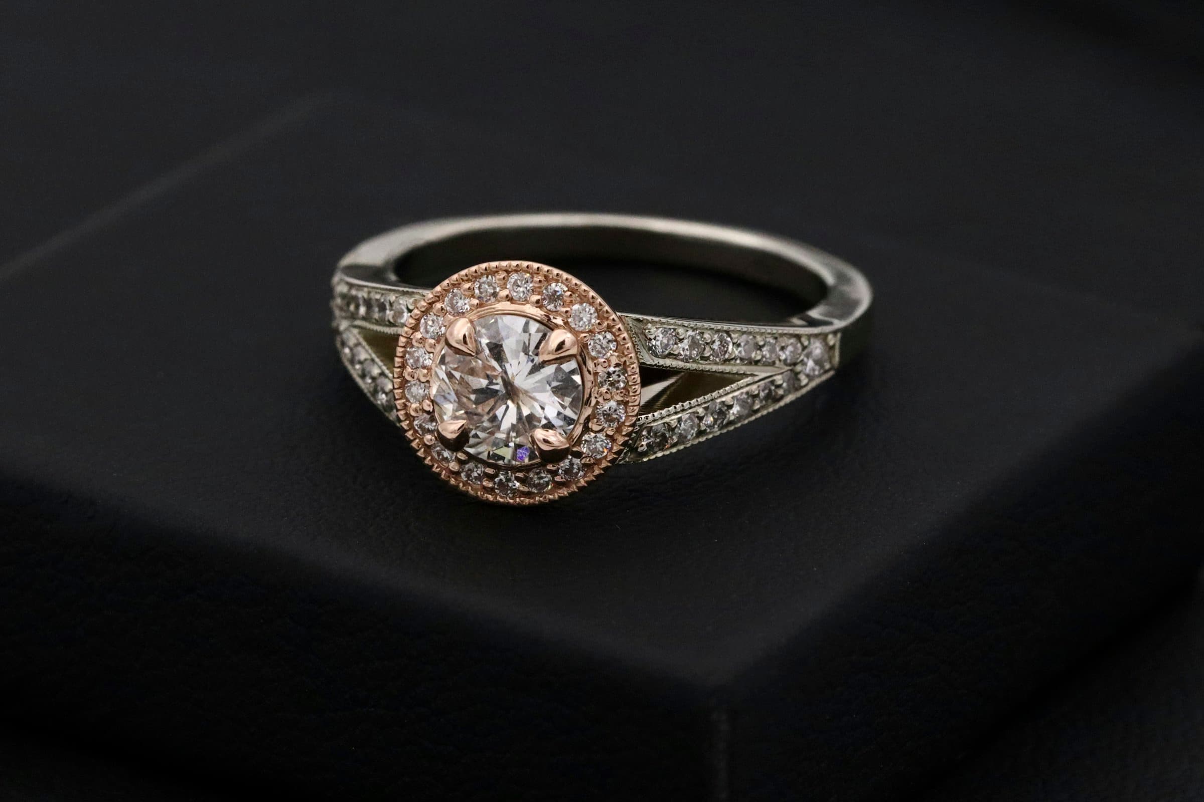 A diamond halo ring catching the light against a dark ground